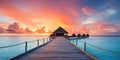 Sunset on Maldives island, luxury water villas resort and wooden pier. Beautiful sky and clouds and beach background for summer Royalty Free Stock Photo