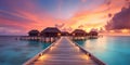 Sunset on Maldives island, luxury water villas resort and wooden pier. Beautiful sky and clouds and beach background for summer Royalty Free Stock Photo