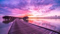 Sunset on Maldives island, luxury water villas resort and wooden pier. Beautiful sky and clouds and luxury beach background Royalty Free Stock Photo