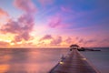 Sunset on Maldives island, luxury water villas resort and wooden pier. Beautiful sky and clouds Royalty Free Stock Photo