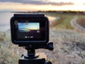 An action camera shooting the time-lapse of the sunset in the meadow near the estuary in early autumn. Royalty Free Stock Photo