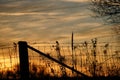 Sunset through metal and wooden fence