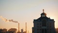 Sunset. Metro sign at the top of the building. Industry chimney on the background