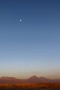 Sunset at the Moon Valley Valle de la Luna with the Licancabur volcano and the moon in the background, Atacama, Chile Royalty Free Stock Photo