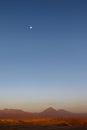 Sunset at the Moon Valley Valle de la Luna with the Licancabur volcano and the moon in the background, Atacama, Chile Royalty Free Stock Photo