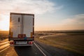 Sunset on the motorway and a truck shot from the passenger seat through a dirty windscreen, blurred focus