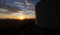 Sunset on a mountain beside a rustic water tank