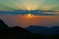 Sunset in the mountains. Beautiful view of the setting sun, mountains and clouds. Royalty Free Stock Photo