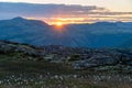 Sunset in the mountains with cotton flowers infront during summer holiday. warm sunburst over peer gynt cabin, formokampen and roa