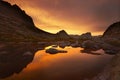 Sunset in mountains near lake. Sunlight reflected on mountain tops. Golden light from sky reflected in a mountain lake. Ergaki.