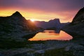 Sunset in mountains near lake. Sunlight reflected on mountain tops. Golden light from sky reflected in a mountain lake. Ergaki. Royalty Free Stock Photo