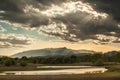 sunset in the mountains with rays of light passing through the valley, thick clouds with rays of light illuminated the lake in