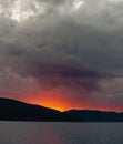 Sunset in the Mountains, Sun Disk Sets Below the Horizon, Sky is Covered with Gray Sheetlike Clouds. Background. Copy Royalty Free Stock Photo