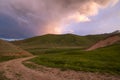 Sunset in the mountains of Tien Shan. Pastures on the background of snow-capped peaks of the mountain range Royalty Free Stock Photo