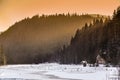 Sunset in the mountains in winter time on the frozen Lacul Rosu lake