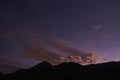 Sunset in nature, soft warm sunlight, moving clouds and silhouette of mountains Royalty Free Stock Photo