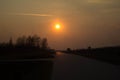 Sunset near the road. The big red sun at sunset. Background. Royalty Free Stock Photo