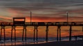 Colorful Sunset at ocean coast with silhouette of pier and photo Royalty Free Stock Photo