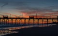 Colorful Sunset at ocean coast with silhouette of pier and photo Royalty Free Stock Photo