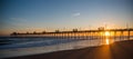 Colorful Sunset at ocean coast with silhouette of pier and photo Royalty Free Stock Photo