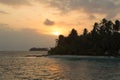 Sunset, ocean and coconut trees near paradisiac island Royalty Free Stock Photo