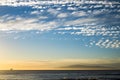 Sunset on the ocean with ferry boat cruise traveling at the horizon and some surfers on the water waiting for some waves to train Royalty Free Stock Photo