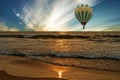 Sunset ocean waves, tropical beach with flying hot air balloon Royalty Free Stock Photo