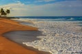 Sunset oceanview, sandy beach with white foam on it