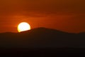 Sunset orange and the sun setting over the mountains of the city of Madrid and some clouds in the sky, in Spain. Europe. Royalty Free Stock Photo