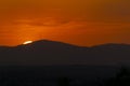 Sunset orange and the sun setting over the mountains of the city of Madrid and some clouds in the sky, in Spain. Europe. Royalty Free Stock Photo