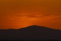 Sunset orange and the sun setting over the mountains of the city of Madrid and some clouds in the sky, in Spain. Europe. Royalty Free Stock Photo