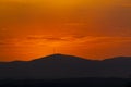 Sunset orange and the sun setting over the mountains of the city of Madrid and some clouds in the sky, in Spain. Europe. Royalty Free Stock Photo