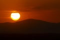 Sunset orange and the sun setting over the mountains of the city of Madrid and some clouds in the sky, in Spain. Europe. Royalty Free Stock Photo