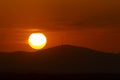 Sunset orange and the sun setting over the mountains of the city of Madrid and some clouds in the sky, in Spain. Europe. Royalty Free Stock Photo