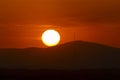 Sunset orange and the sun setting over the mountains of the city of Madrid and some clouds in the sky, in Spain. Europe. Royalty Free Stock Photo