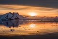 Sunset over antarctic lagoon with drifting icebergs and snow peaks in the background, Lemaire Channel