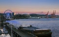 Sunset over Bell Harbor Marina on the Seattle Waterfront with Mount Rainier, Great Wheel and the harbour cranes in the background Royalty Free Stock Photo