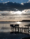 Sunset over boat pier dock wooden structure jetty in river lake Royalty Free Stock Photo