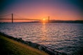 Sunset over the bridge on 25 April in Portugal and the Tejo river by boat