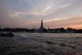 Sunset over the Buddhist temple Wat Arun. The water surface of the Chao Phraya River