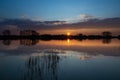 Sunset over a calm lake with reeds, the evening cloud reflecting in the water Royalty Free Stock Photo