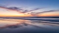 Sunset over calm ocean with reflective wet sand and clouds beach calm water Royalty Free Stock Photo