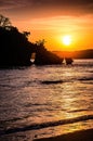 Sunset over a calm sea with silhouette of an island. Tropical ocean sunset with island in the water. Vertical mobile background. Royalty Free Stock Photo