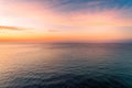 Sunset over calm water with small lonely boat.