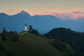 Sunset over The Church of St. Primoz and Felicijan in the village of Jamnik. The last ray of sun on the Alps in Slovenia. Vertical Royalty Free Stock Photo