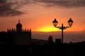 Sunset over the city with the silhouette of a lamppost and the tower of a building Royalty Free Stock Photo