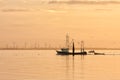 Sunset over Dutch sea with fishing ship returning to harbor