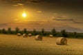 Sunset over farm field with hay bales. Czech countryside Royalty Free Stock Photo