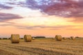 Sunset over farm field with hay bales Royalty Free Stock Photo