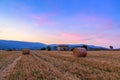 Sunset over farm field with hay bales near Sault Royalty Free Stock Photo